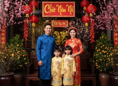 Một gia đình mặc áo dài truyền thống tươi cười trước không...