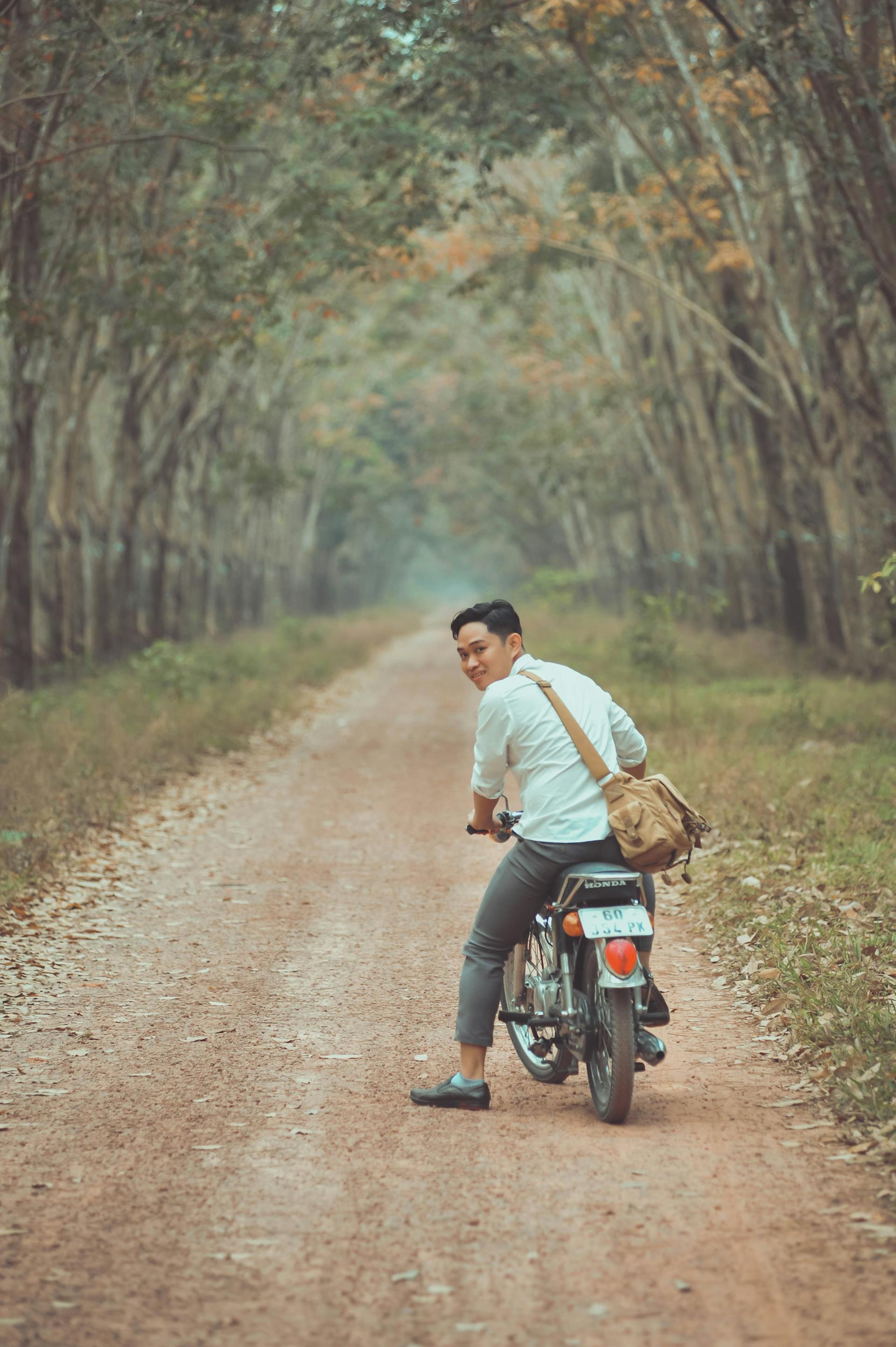 Xe máy, motorbike, vườn cao su, rubber plantation, hàng cây, row of trees, đường đất, dirt road,  thanh niên, young man - Bảo Huỳnh